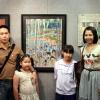 Grand prize winner from Thailand with her younger sister and parents in front of winning work